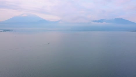 Fishing-boat-in-the-distance-slowly-crossing-Rawa-Pening-lake-in-Indonesia