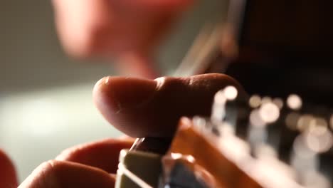 male hands plucking acoustic guitar strings