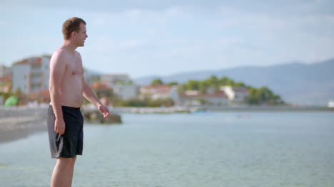 Young-Man-Tourist-Walking-On-Sea-Shore-In-Summer