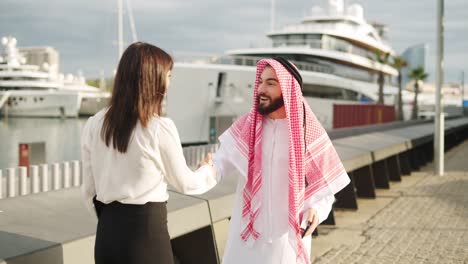 arab businessman using smartphone while waiting for female professional yacht broker in port