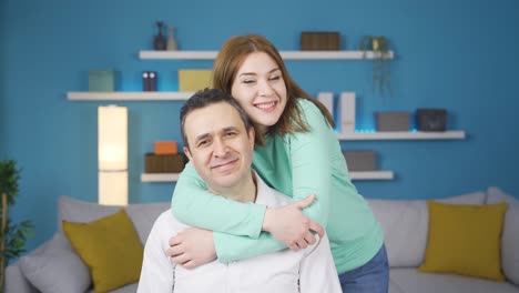 Young-adult-girl-hugs-her-father.