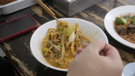 Mann-Isst-Berühmtes-Traditionelles-Kanom-Jeen-Mit-Soicy-Basissuppe,-Essen-In-Lana-Chiang-Mai-Schmeckt-Reisnudeln-Mit-Suppenstil