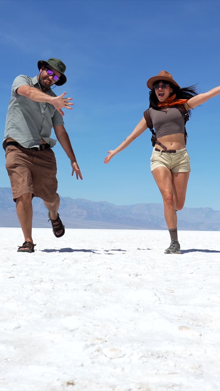 Coppia felice che corre e salta su una vasta salina