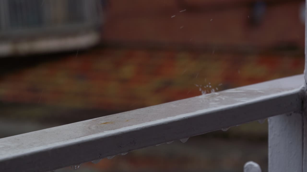 Raindrops Splashing and Dripping on a Metal Railing