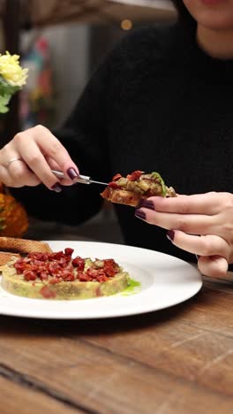 woman eating a delicious eggplant and tomato sandwich