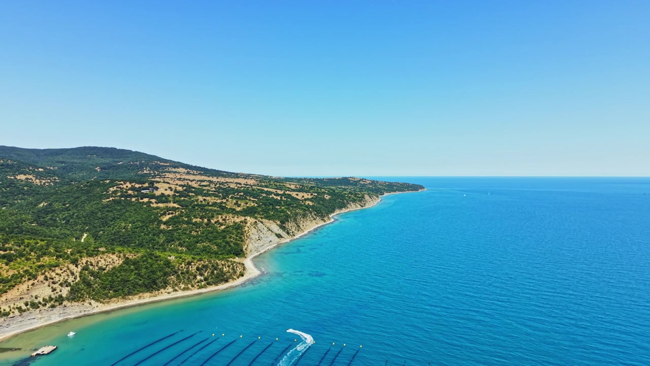 Costa lungo il mare con acqua limpida e colline verdi in una giornata di sole in una zona costiera
