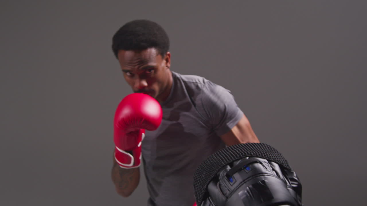 Studio Shot Of Male Boxer Sparring Working Out With Trainer Wearing Punch Mitts Or Gloves Practising For Fight 10