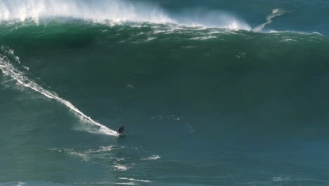 Slow-motion-of-a-big-wave-surfer-riding-one-of-the-largest-monster-waves-in-Nazaré,-Portugal