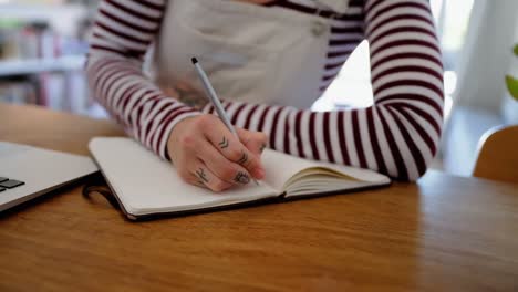 woman writing on diary at home 4k