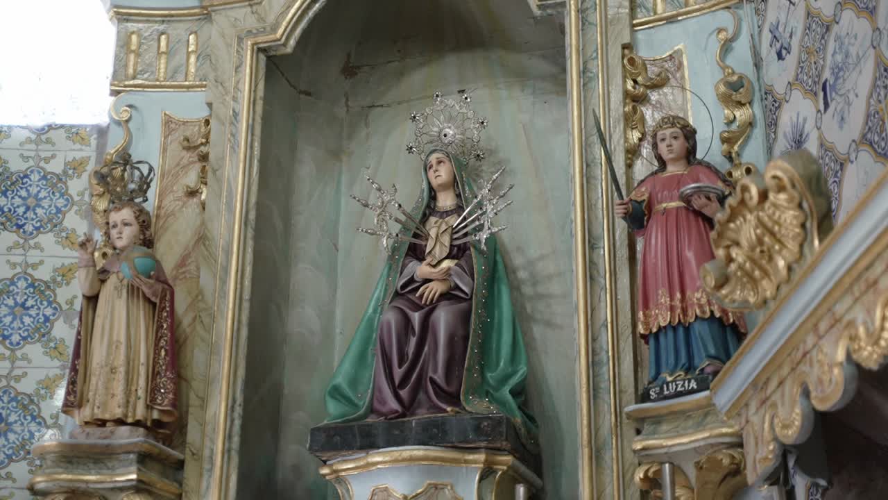Ornate church altar featuring statues of the Virgin Mary and saints in sacred decor