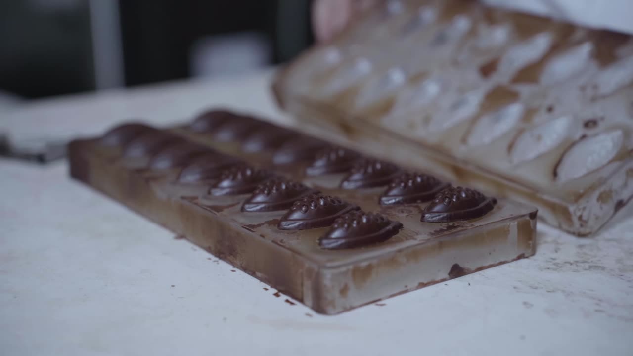 손은 초콜릿 모형을 열고, 수공예 초콜릿 사탕을 드러니다.