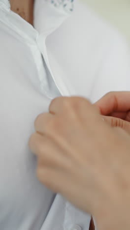 careful woman buttons elegant white shirt of beloved husband in room closeup slow motion. lady takes care of partner. family life and love relationship