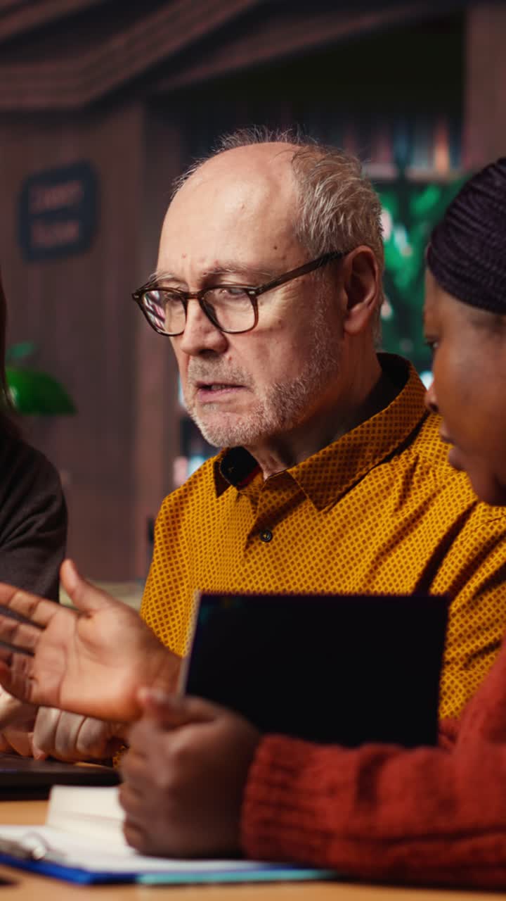 Vertical Video Mature diverse colleagues writing notes and ideas in campus study room