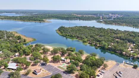 moving quickly to the left above a pretty blue lake and recreational area that has shoreline, boat ramp and a campsite on the other side