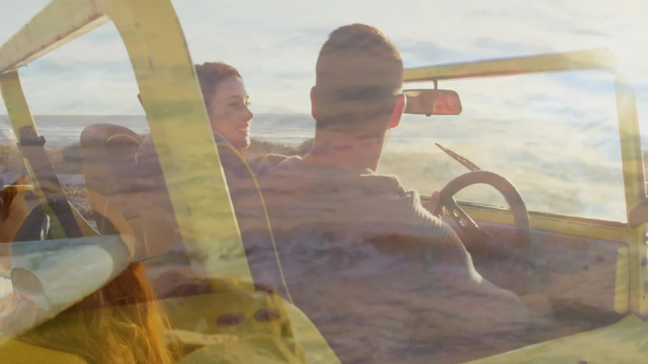 Driving convertible, people with animation of ocean waves overlaying scenic view