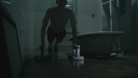 pale bald skinny man looks into the mirror in the creepy old bathroom at night
