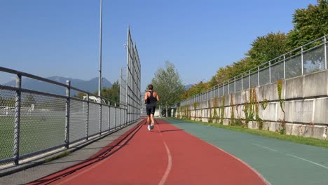 sportsman running on a sports track during sunny day