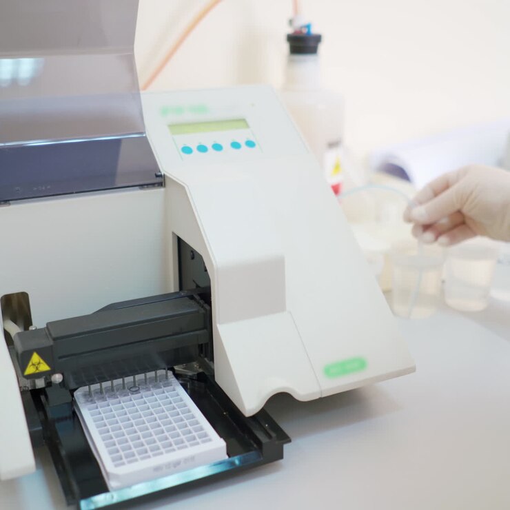 Automated equipment in the laboratory. Modern machine for making sample researches. Medical worker controls the work of robotic machine.
