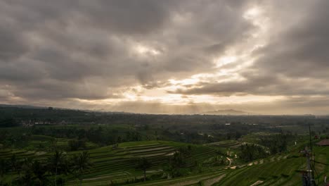 Timelapse-of-the-sunrise-and-lightrays-over-the-ricefield-paddies-of-Jatiluwih,-Bali-Indonesia-in-4k