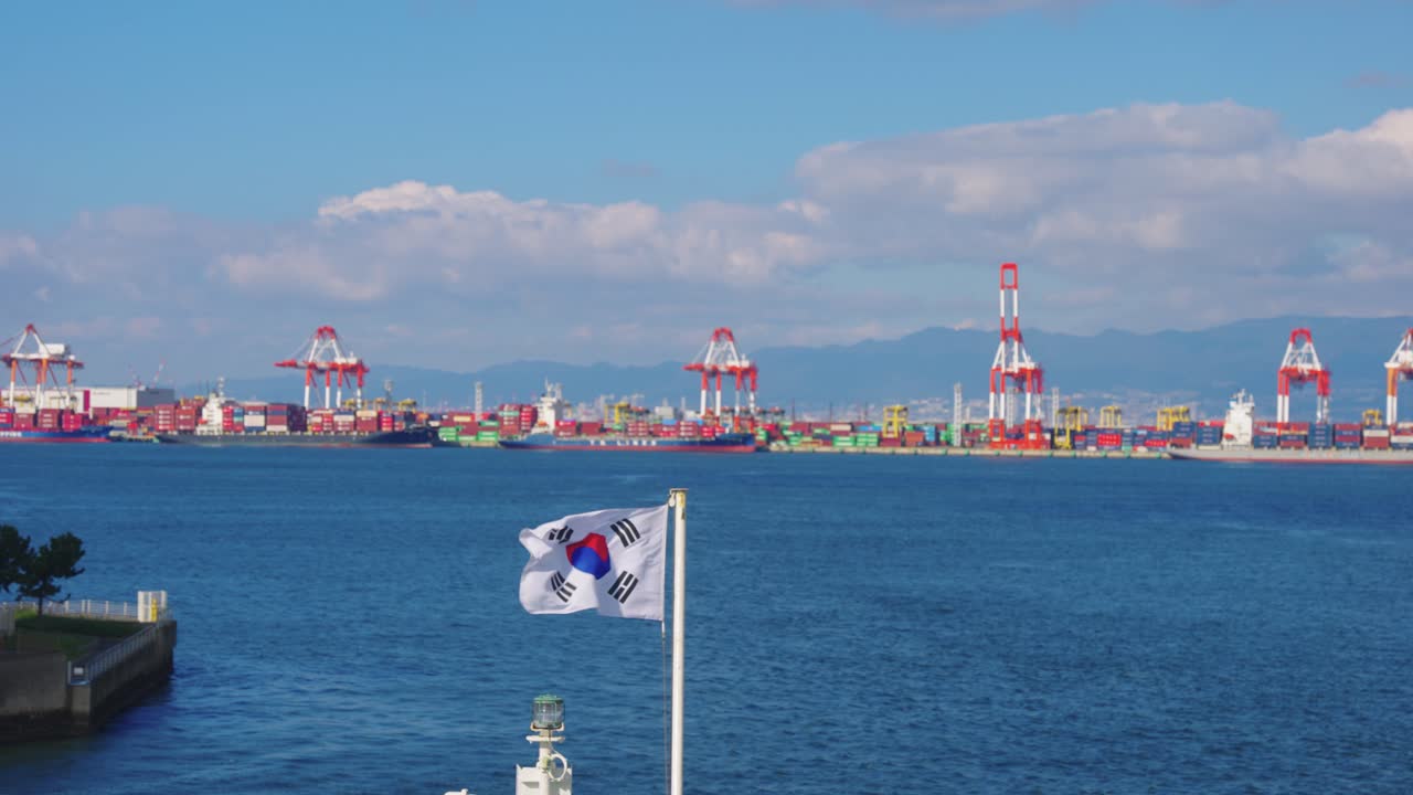 South Korea Flag Flying over Ocean with Shipping Cargo and Port in Background