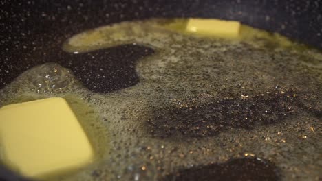 cs butter melting into a pan creating frying bubbles of fat, health concept