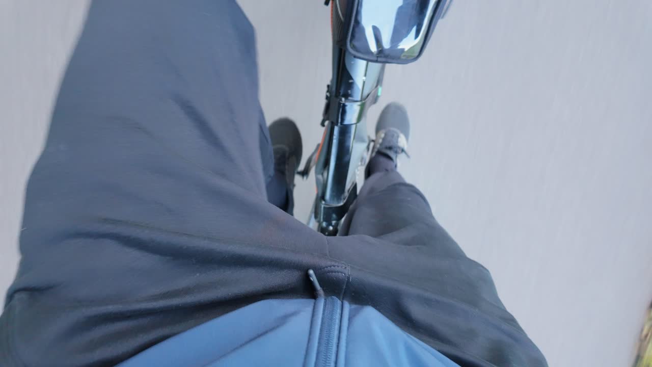 Cyclist in motion seen from above pedaling smoothly on quiet city street