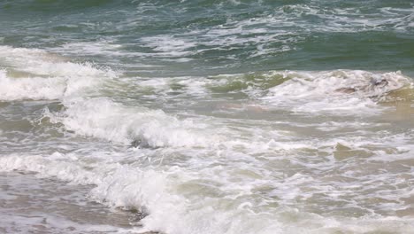 sequential view of ocean waves hitting the beach