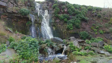 Aerial-drone-footage-of-a-tall-rocky-waterfall-in-the-Yorkshire-Dales,-Pennies