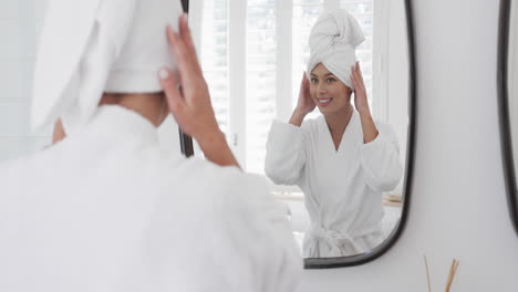 Mujer-Birracial-Feliz-Tocando-Su-Cara-Mirando-En-El-Espejo-En-El-Baño,-Cámara-Lenta