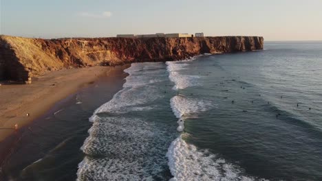 Aerial-view-of-surfers-at-sunset-on-a-Portugish-beach