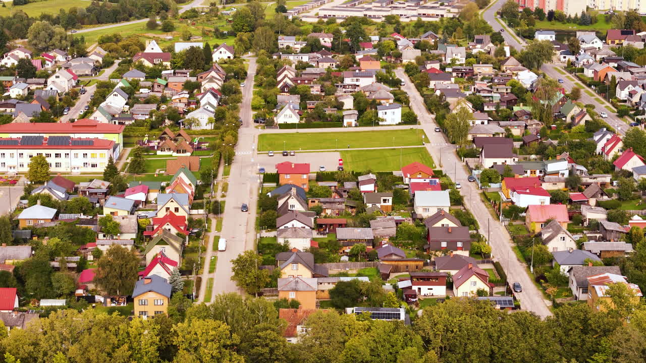 Drone footage of a suburban residential area in Cesis, Latvia, featuring houses and streets.