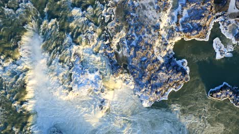 aerial view of frozen urriðafoss waterfall in iceland with wild river