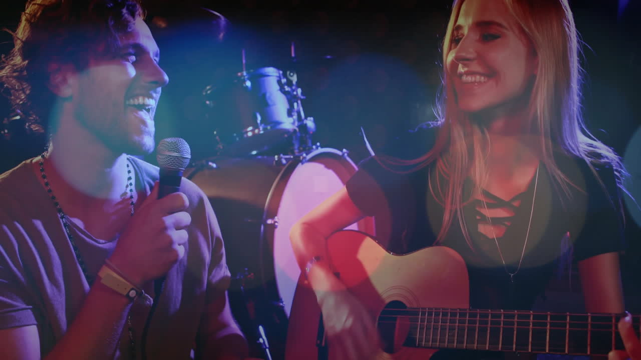 Performing duo singing and playing guitar on stage, featuring animated music note and wave overlays