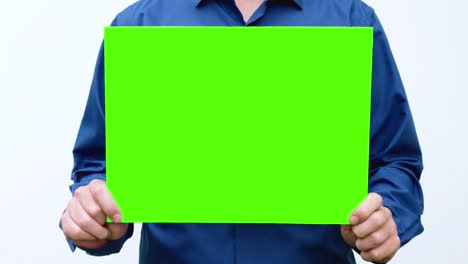 man holds a green screen in his hands