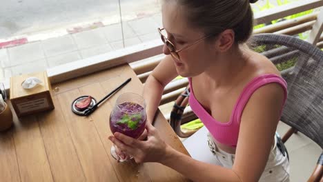 woman enjoying a purple drink at a cafe