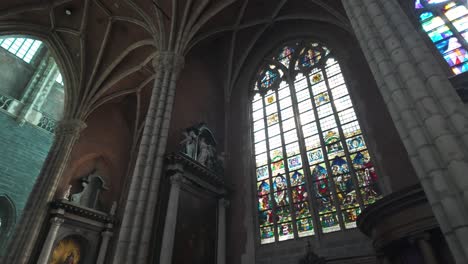 a grand gothic cathedral interior with soaring arches, statues, and stained glass windows