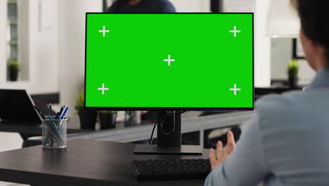 worker at desk with greenscreen desktop