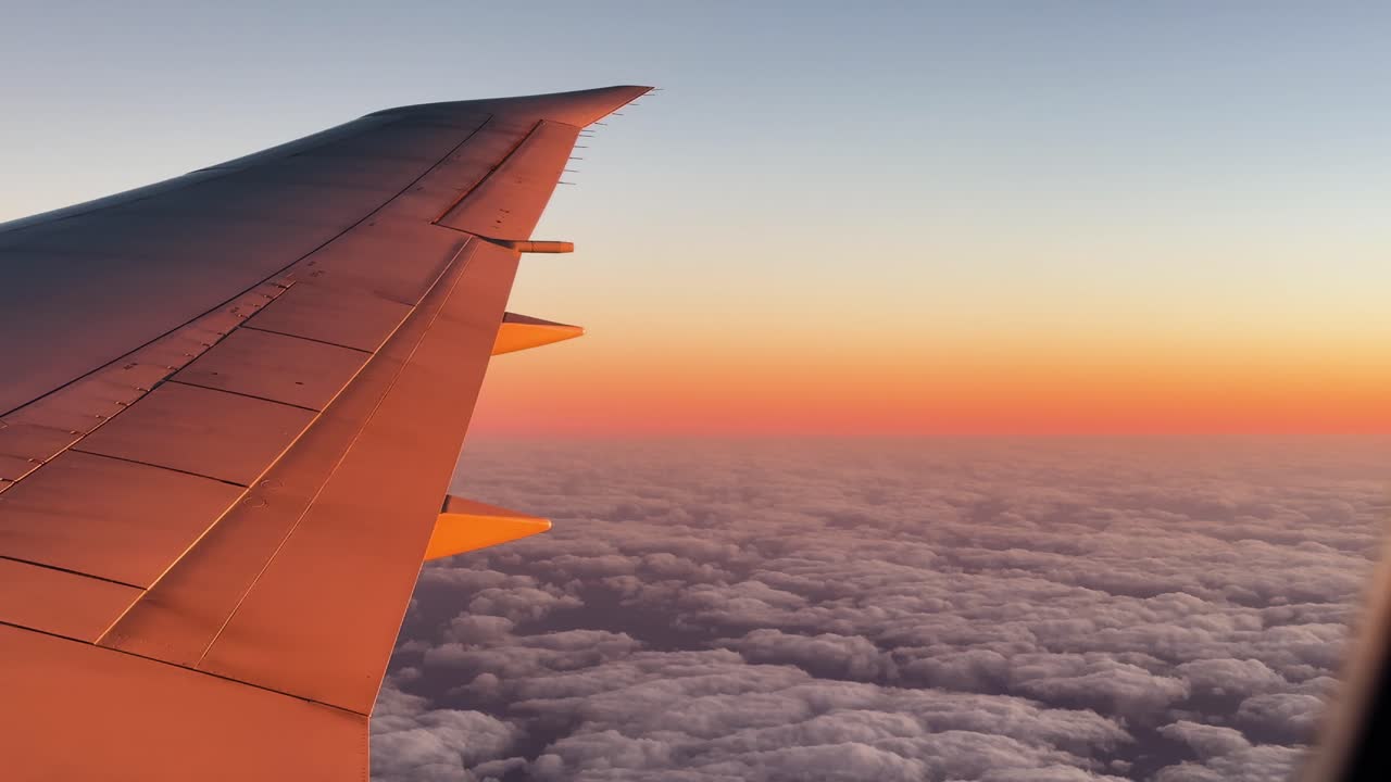 Ala di aeroplano sopra le nuvole al tramonto, con una sensazione di serenità e pace