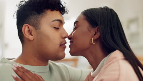 couple on couch, kiss in living room of home