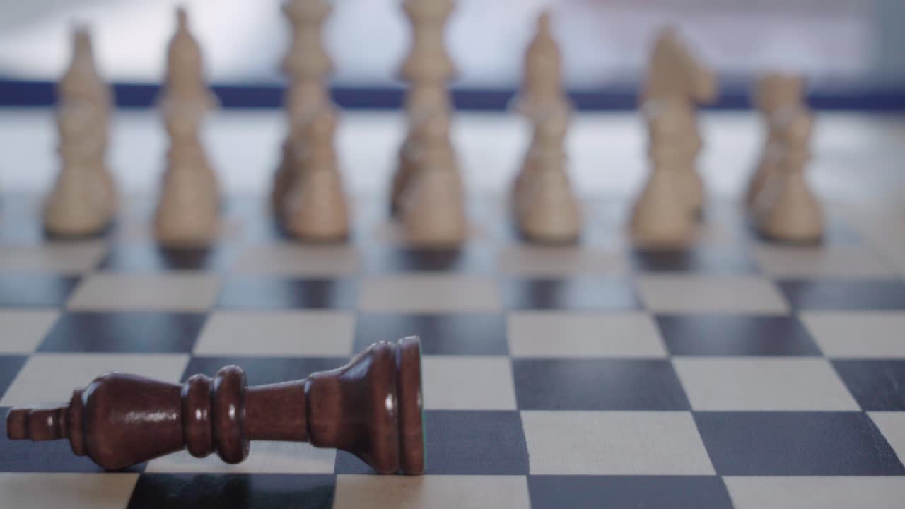 킹 체스 조각이 소프트 포커스 백군 앞에서 넘어지고, 근접 촬영