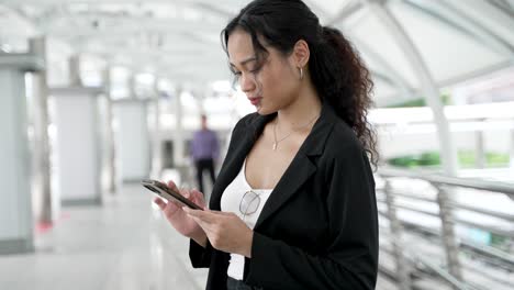 mujer joven usando un teléfono inteligente en un entorno urbano