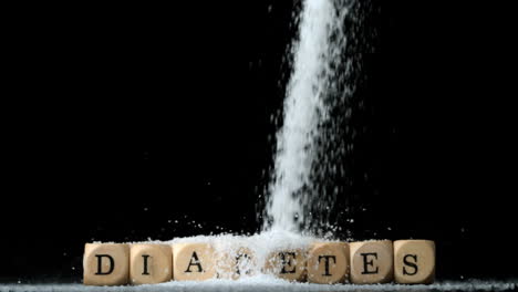 sugar powder being poured over dice spelling out diabetes