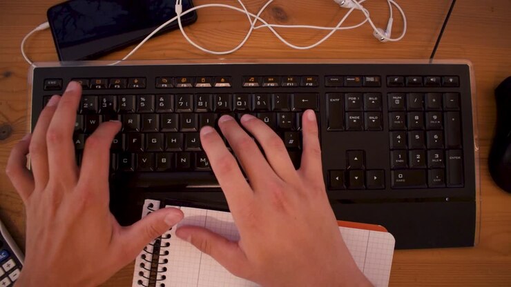 Ung mand skriver en tekst på sin computer ved hjælp af et tastatur-1