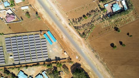 Foque-Hacia-Abajo-De-Una-Granja-De-Paneles-Solares-En-África-Rural--Energía-De-Renovación-Verde-ODS--Granja-Fotovoltaica-De-Células-De-Paneles-Solares