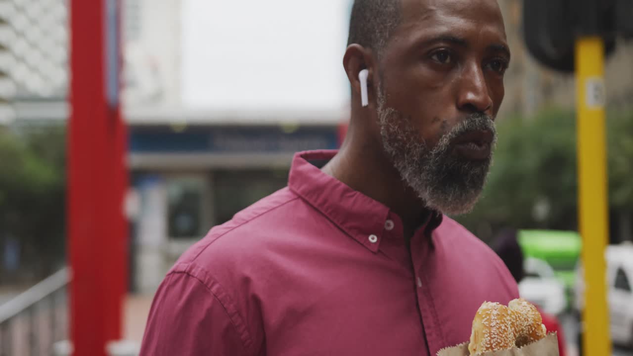 hombre afroamericano comiendo en la calle