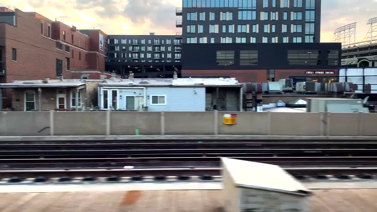 Beautiful sunset over Wrigley Field as the CTA train races by Wrigley Field.