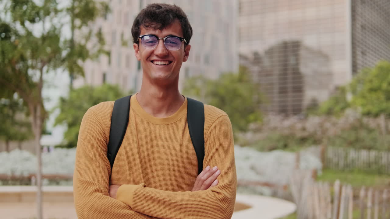 Portrait of European young man, cute geeky male studet smiling outdoors with