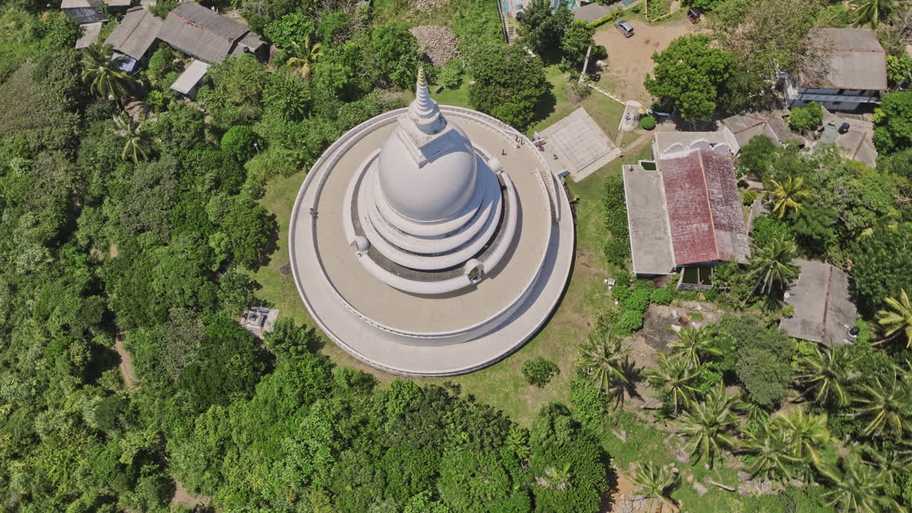 Unawatuna Sri Lanka Aerial v10 birds eye view flyover and around Japanese Peace Pagoda on Rumassala hill, tilt up reveals breathtaking jungle beach and ocean view - Shot with Mavic 3 Cine - April 2023