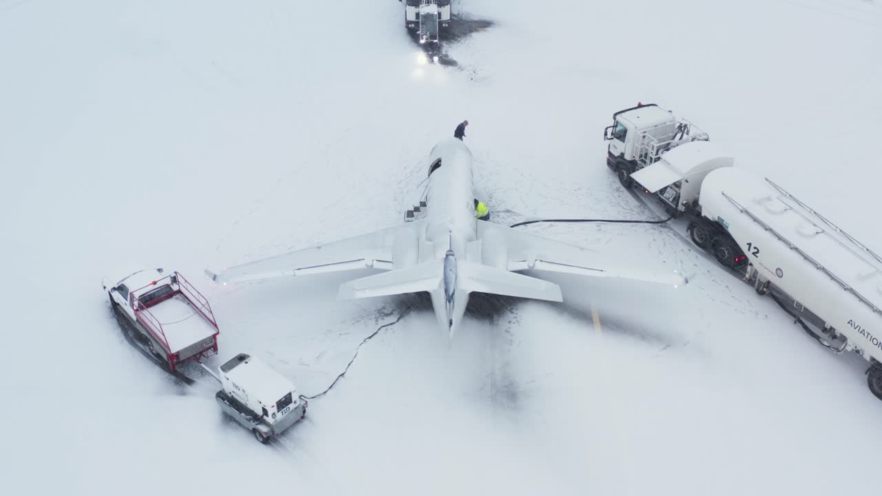 personal del aeropuerto que trabaja en un avión privado embraer emb-505 durante la temporada de invierno
