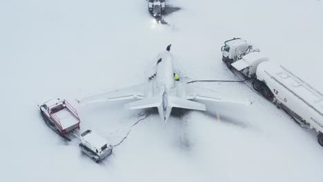 airport personnel working around private embraer emb-505 airplane during winter season